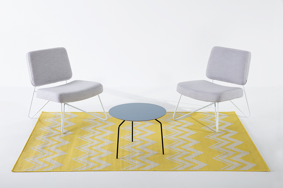 tapis jaune et blanc, fauteuils en tissu gris et pieds métal blanc, table basse bleue et pieds métal noir Bo Concept, agence Parade